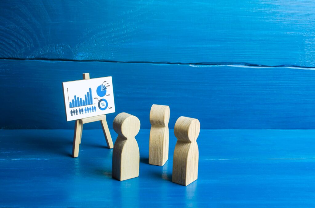 data science visual graphs on easel with wooden toy people